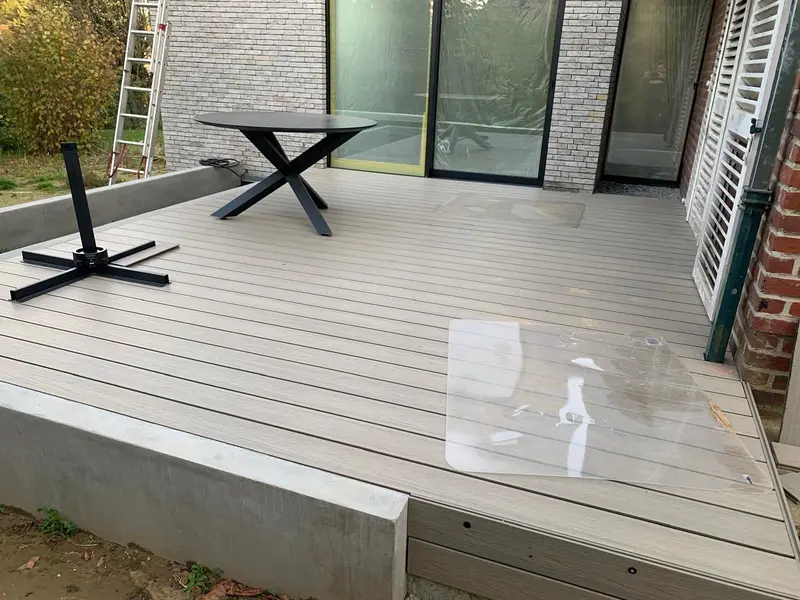 La terrasse en composite devant l’extension achevée, la baie coulissante encore sous film de protection.